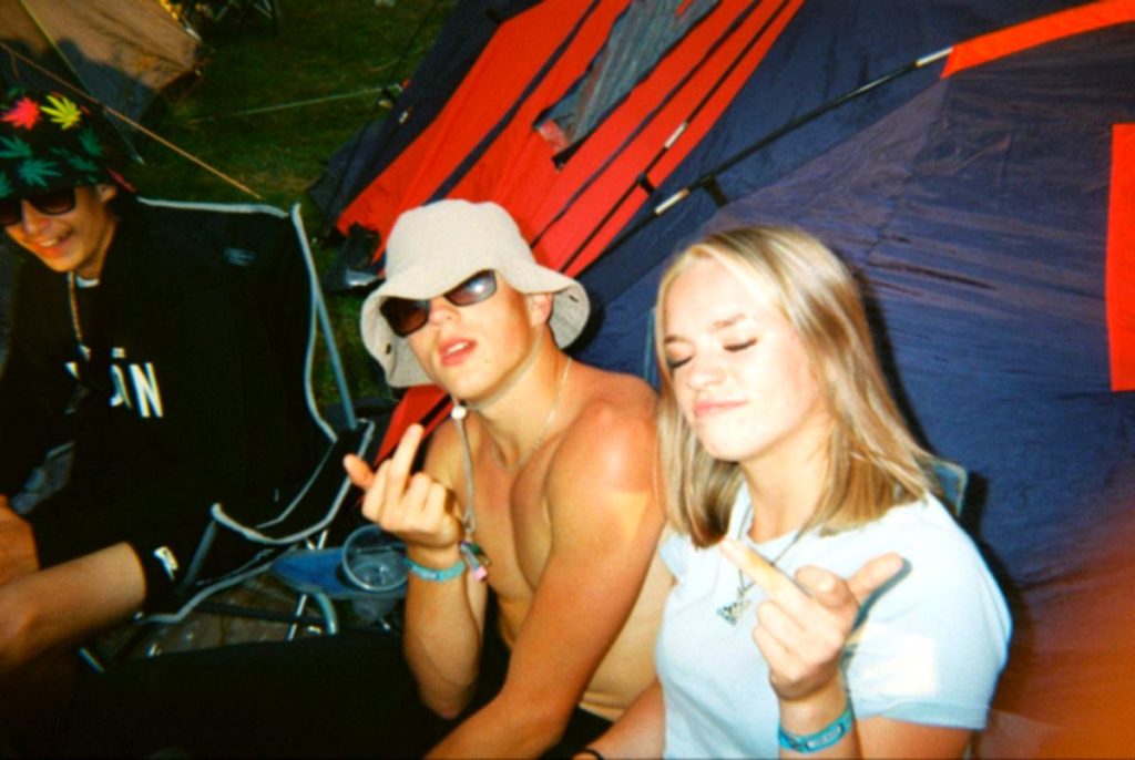 Zwei Freundinnen mit Sonnenbrille und Mütze auf dem Campingplatz